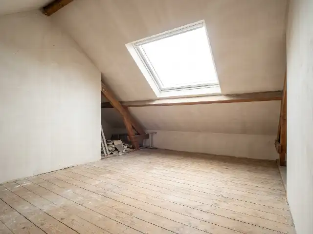 Afgewerkte zolderkamer na het isoleren van het hellende dak